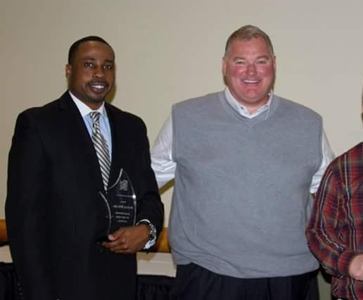 Two Inside/Out Pro Services team members with a glass award won for their work